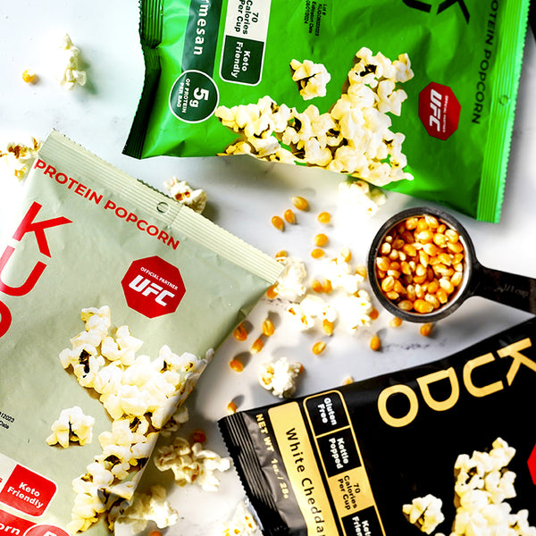 kudo protein popcorn on table with popcorn kernels